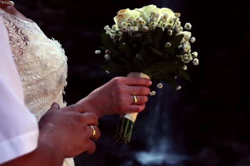 A wedding bouquet held between two hands